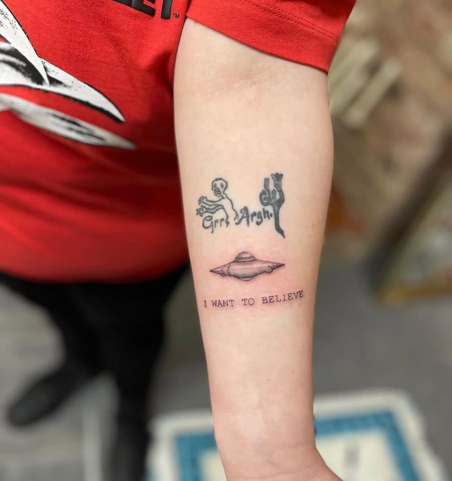 UFO and alien themed forearm tattoo