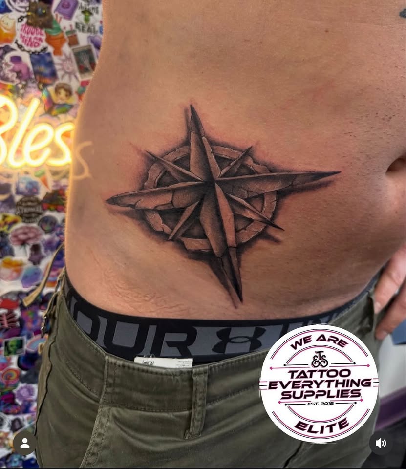Compass star tattoo on stomach