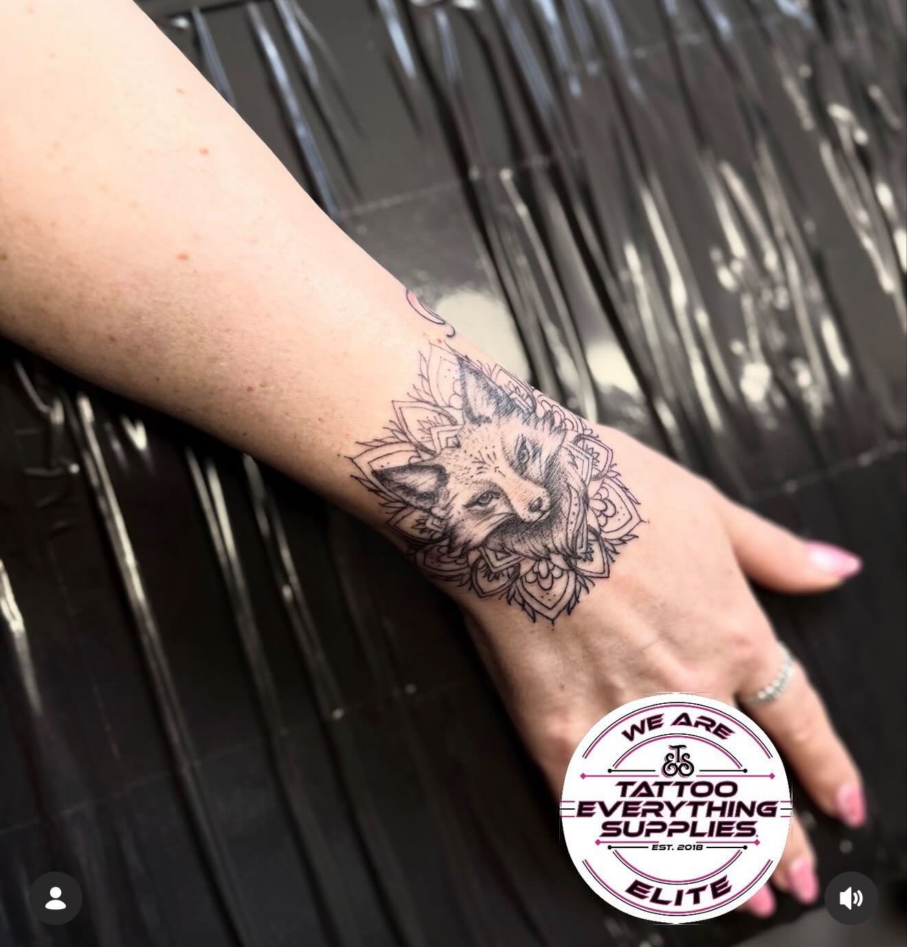 Fine line fox and mandala hand tattoo